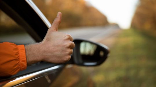 man-giving-thumbs-up-out-his-car-while-road-trip.jpg